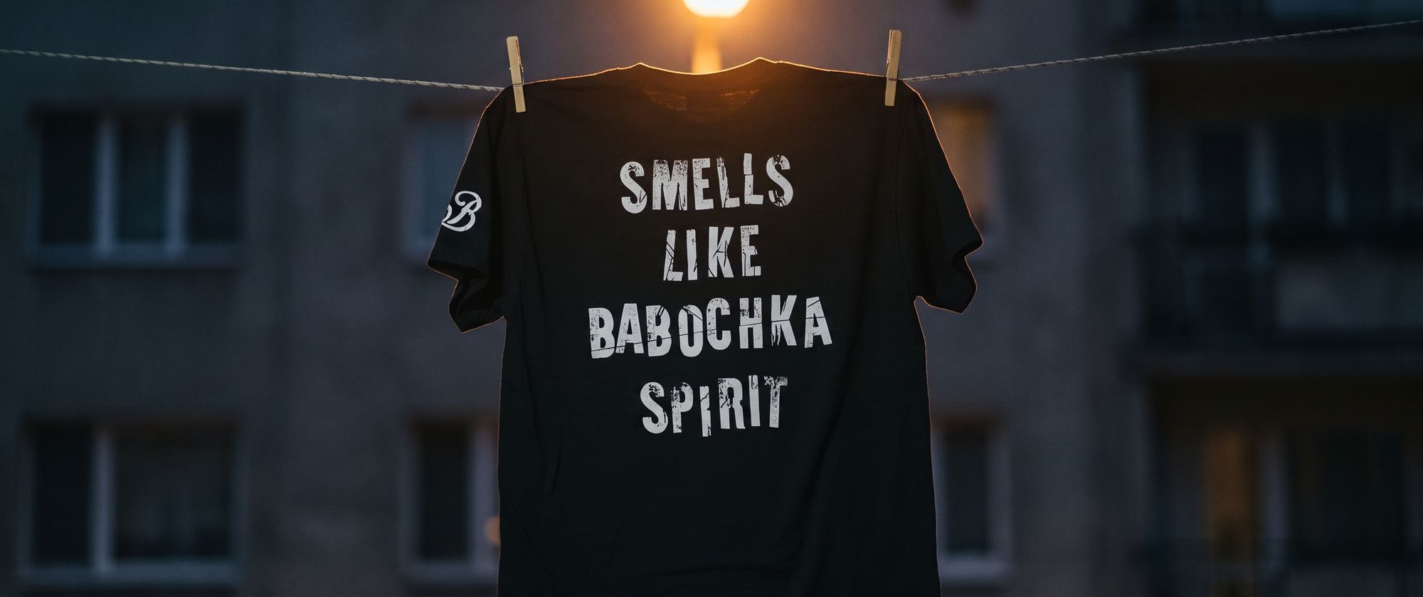 夜の物干しに吊るされた「SMELLS LIKE BABOCHKA SPIRIT」のTシャツ